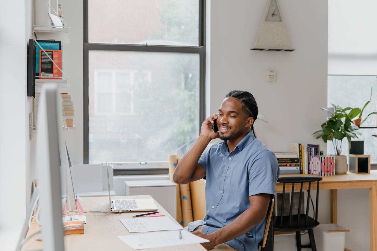 Man sitting at desk in office, talking on phone